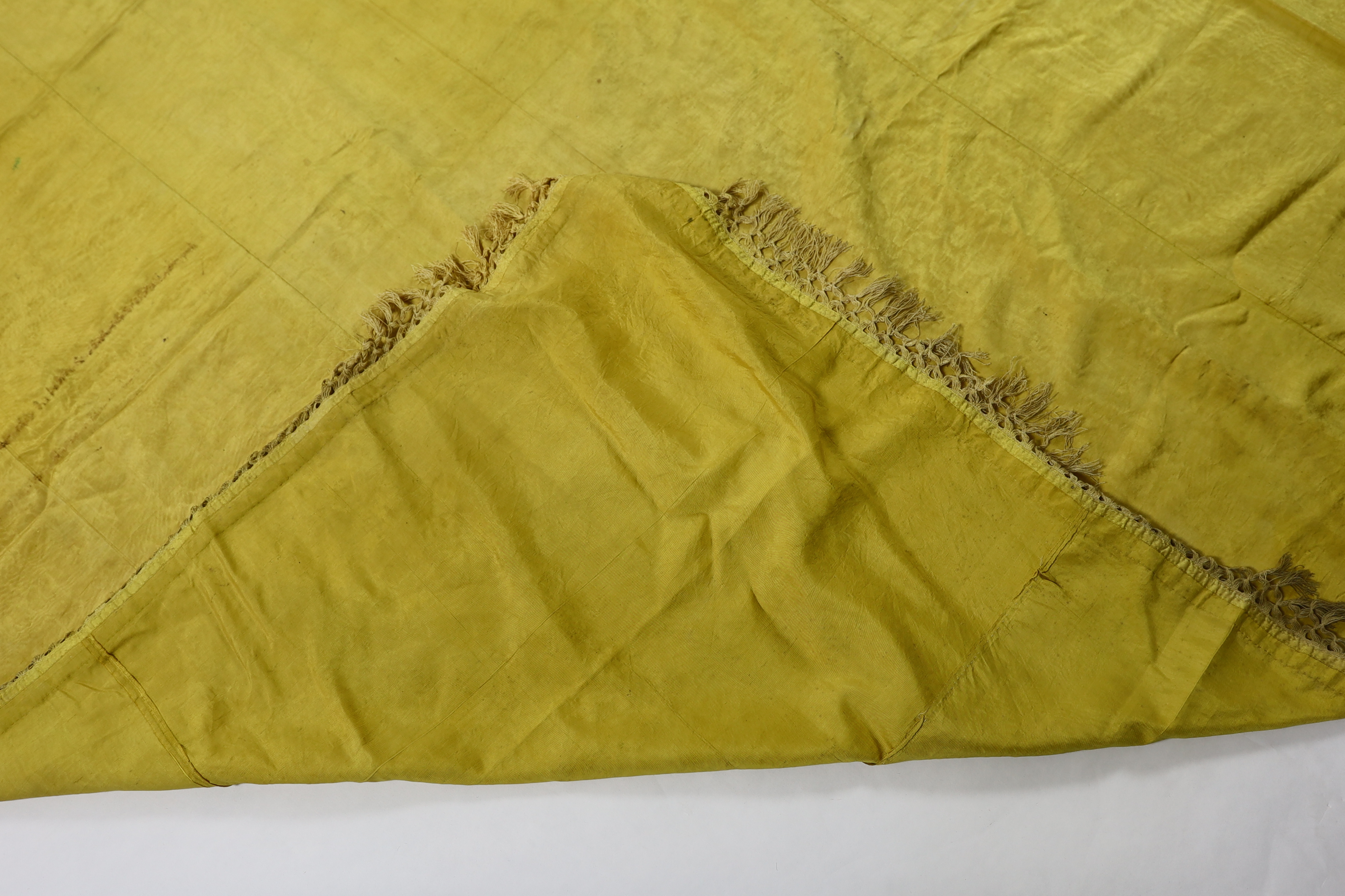 A large Regency yellow silk curtain, with fringed base, French short loom ribbed silk panels made into a wide curtain, with fringing on each side and at the bottom, 9ft wide x 8ft 6in. long